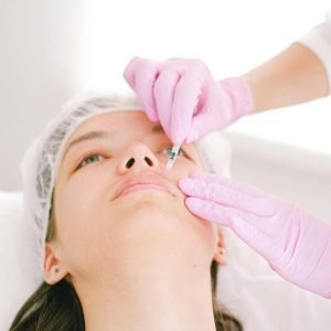 Woman receiving a facial cosmetic injection in a professional clinic setting.